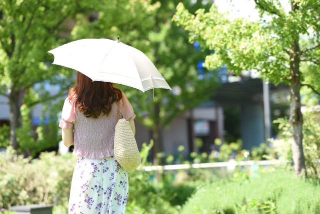 公園で日傘をさす女性