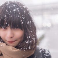 雪が積もる中マフラーを巻いている女性