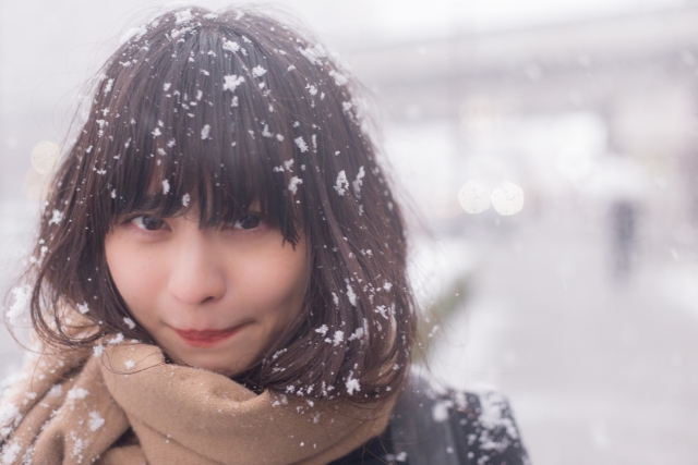 雪が積もる中マフラーを巻いている女性